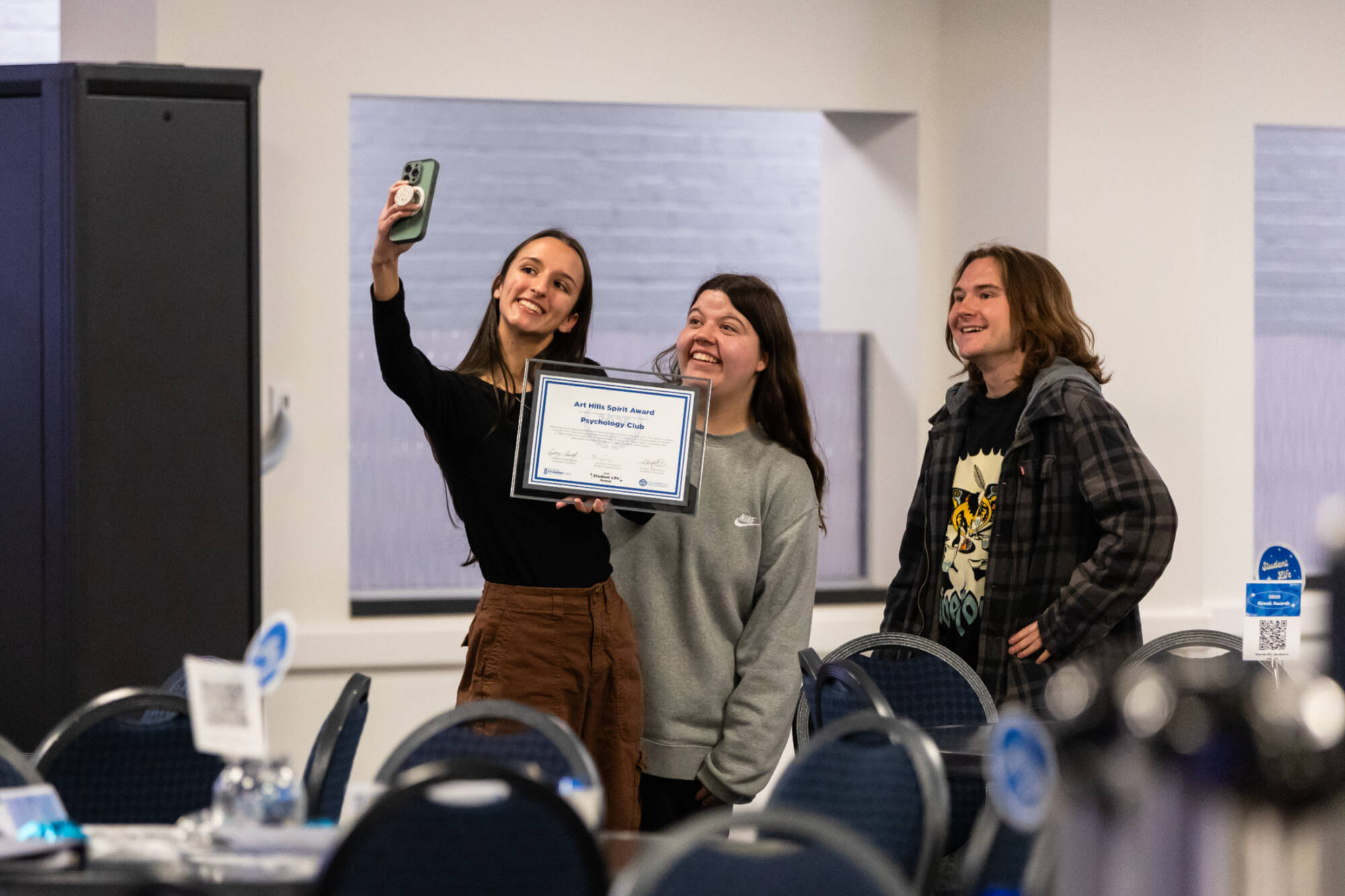 Students taking a selfie while holding up a certificate